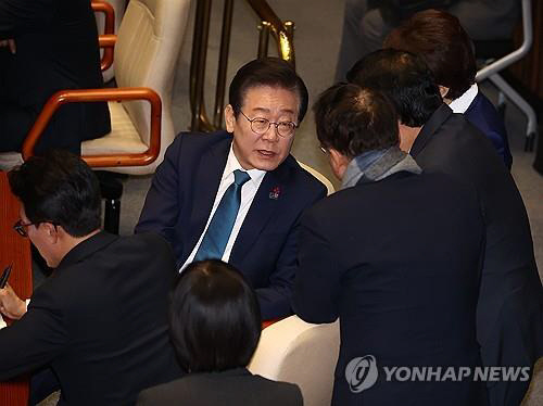이재명 더불어민주당 대표가 5일 국회에서 열린 본회의에 참석해 의원들과 대화를 나누고 있다.<연합뉴스>